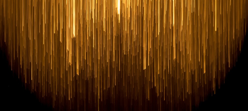 Abstract background with vertical streaks of golden light on black.